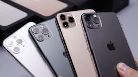 Several smartphones are displayed in a row, showing their back cameras and sleek designs. They feature multiple lenses, indicating advanced photography capabilities. The devices appear to be well-crafted, with a glossy finish in different colors including black, gold, and silver. The iconic logo is visible on each phone.