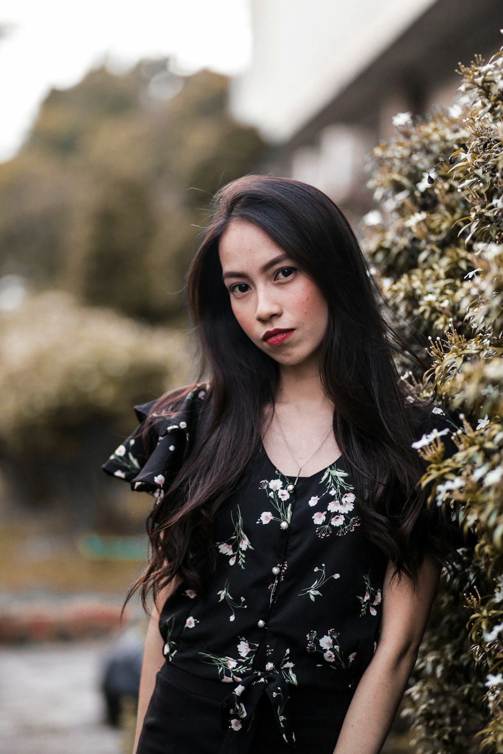 woman in black top standing beside plant