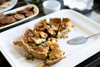 Slices of homemade quiche Lorraine with a golden crust and creamy filling on a wooden board.