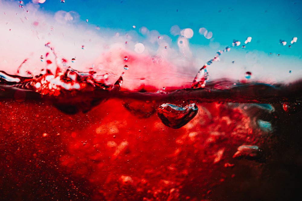 a red and blue background with water drops