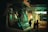 A street-level view at night features the front of a tram with a reflective windshield, illuminated by nearby lights. In the background, a brightly lit sign reads 'OPTUS' from a shop. Silhouettes of people are visible walking on the sidewalk, adding a sense of movement.