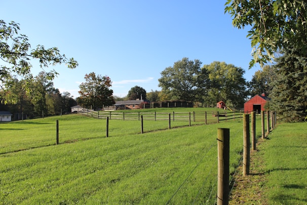 Panoramic view of a large farm fully enclosed by tall, durable metal fencing