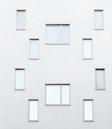 Minimalist architectural facade with warm neutral tones and subtle gold accents.