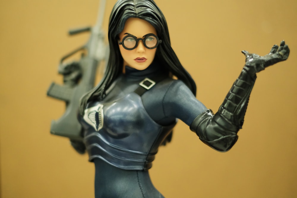 selective focus photography of woman in suit holding rifle action figure