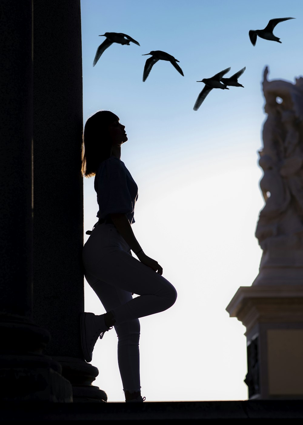silhouette of woman laying on pillar