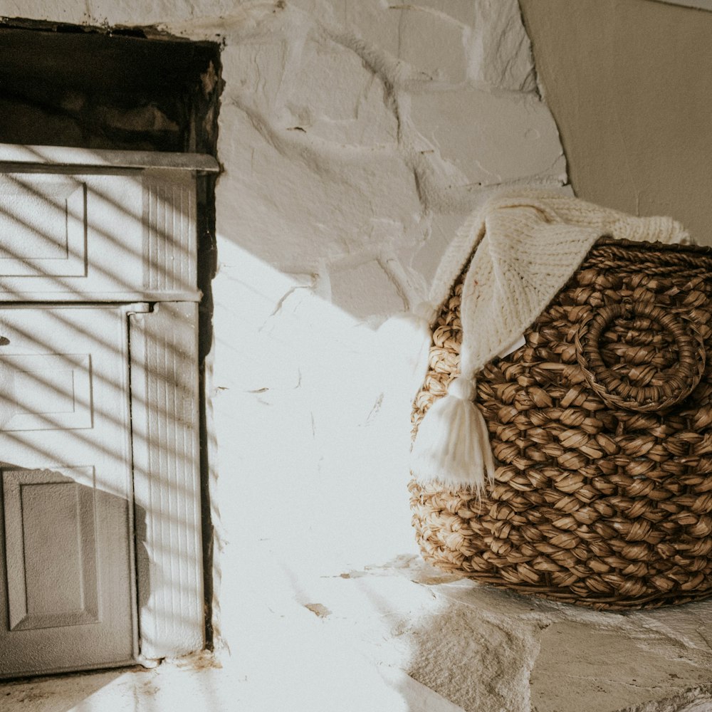 a basket sitting on the floor next to a wall