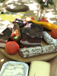 Assorted cold cuts arranged artfully on a platter with fresh herbs and olives.