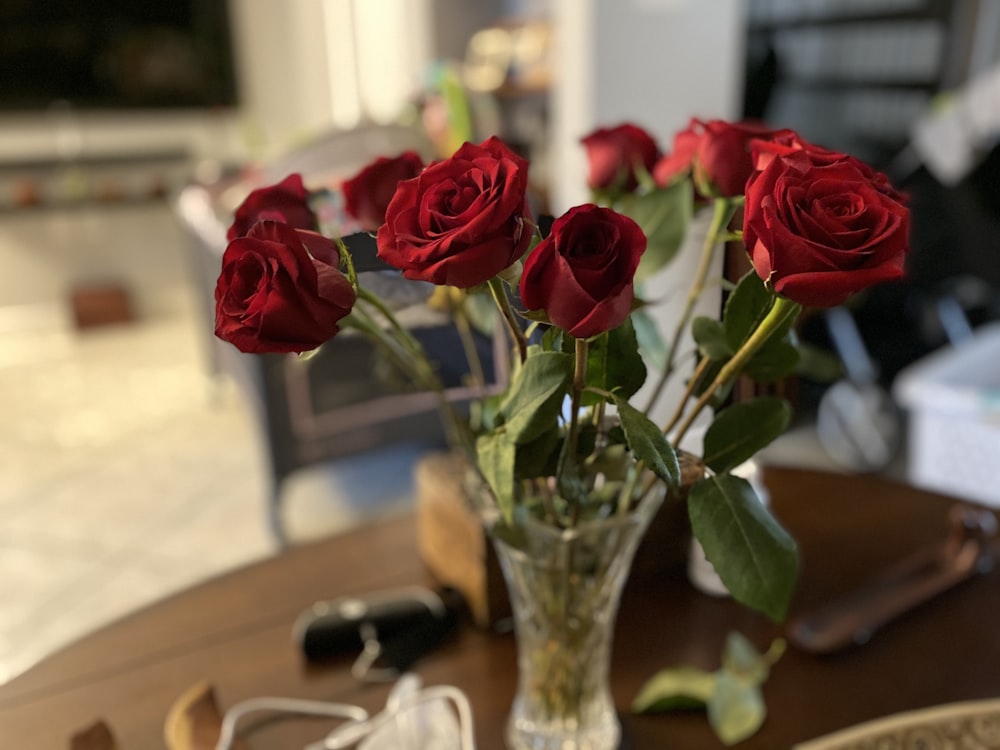 a vase filled with red roses on top of a table