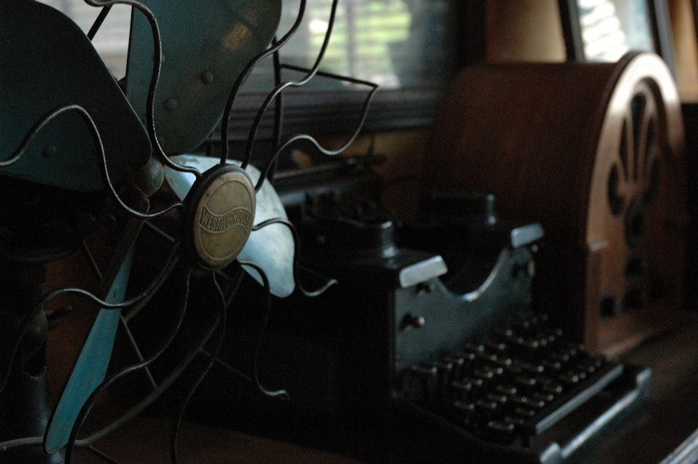 low-light photo of typewriter in between of cathedral radio and parabolic dish