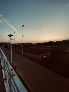 A scenic view of an outdoor paddle court at sunset