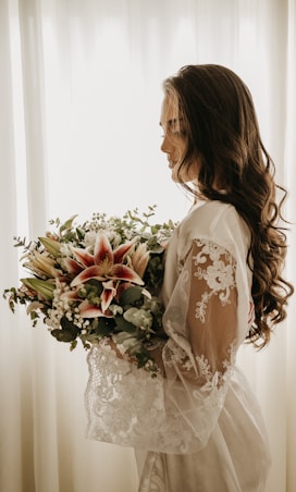 woman in white dress holding bouquet of flowers