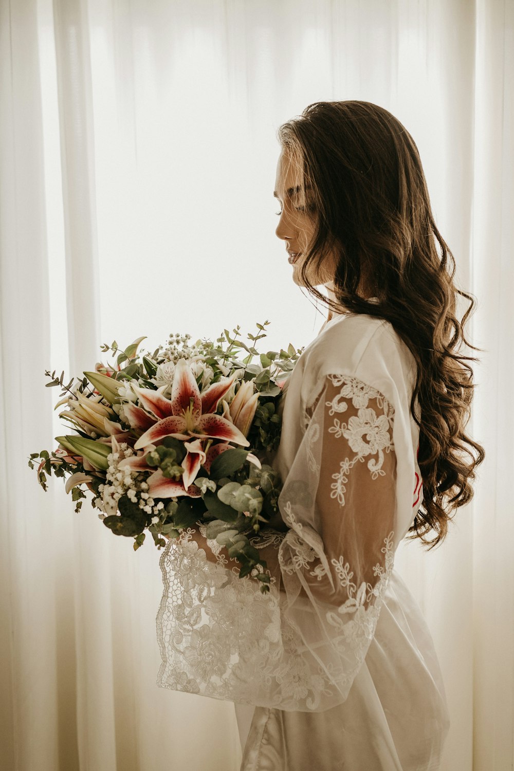 흰 드레스를 입은 여자가 꽃다발을 들고 있다