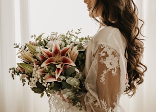 woman in white dress holding bouquet of flowers