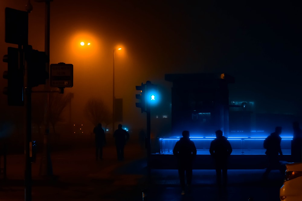 silhouette di persone sulla strada durante la notte