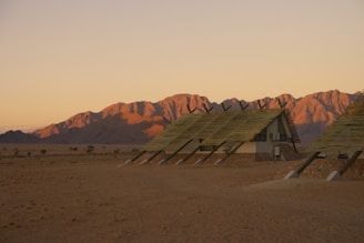 Cozy chalet surrounded by desert landscape at sunset.