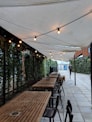 rectangular brown wooden dining inside white awning