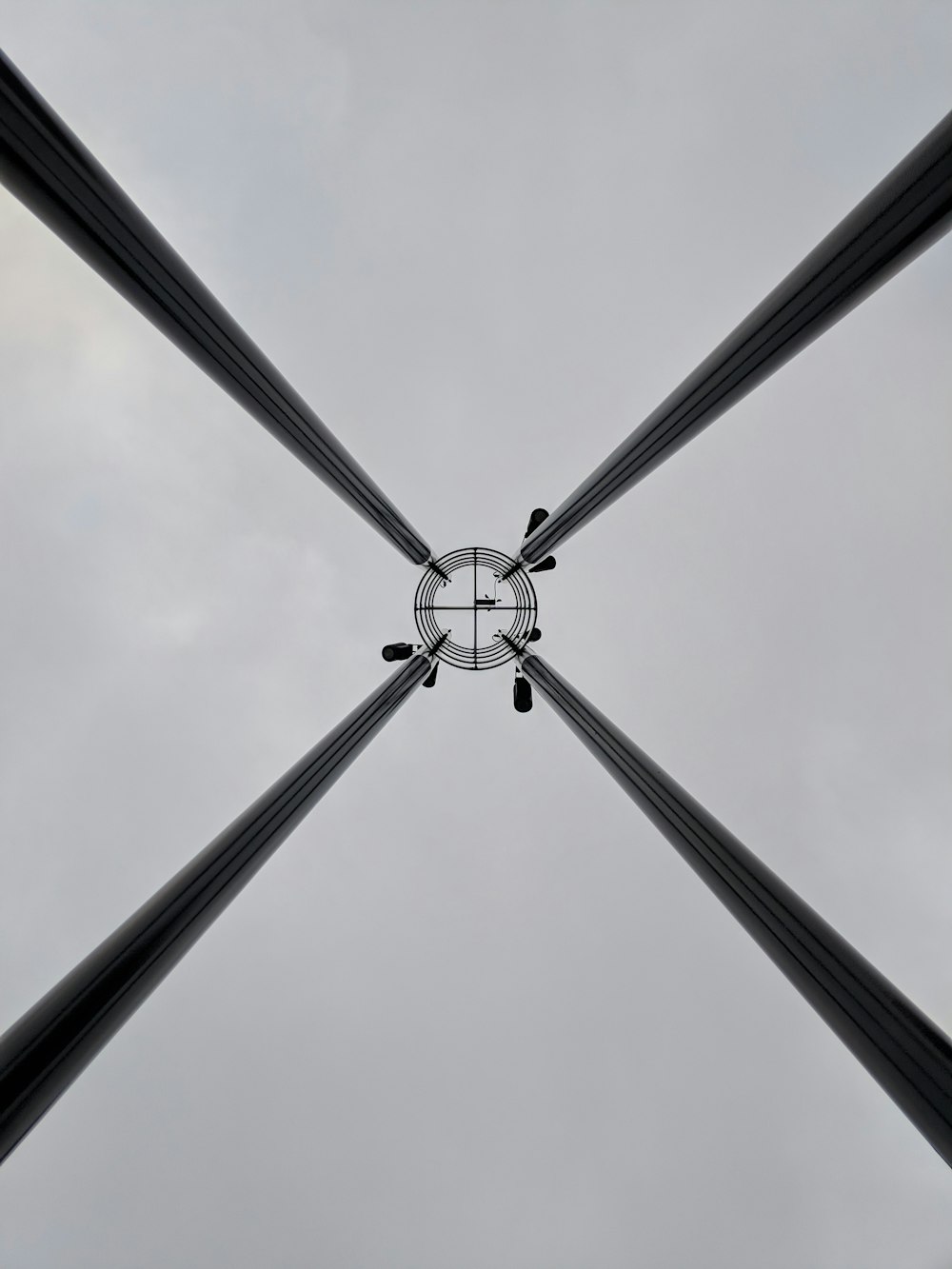 a group of black and white poles with a sky background