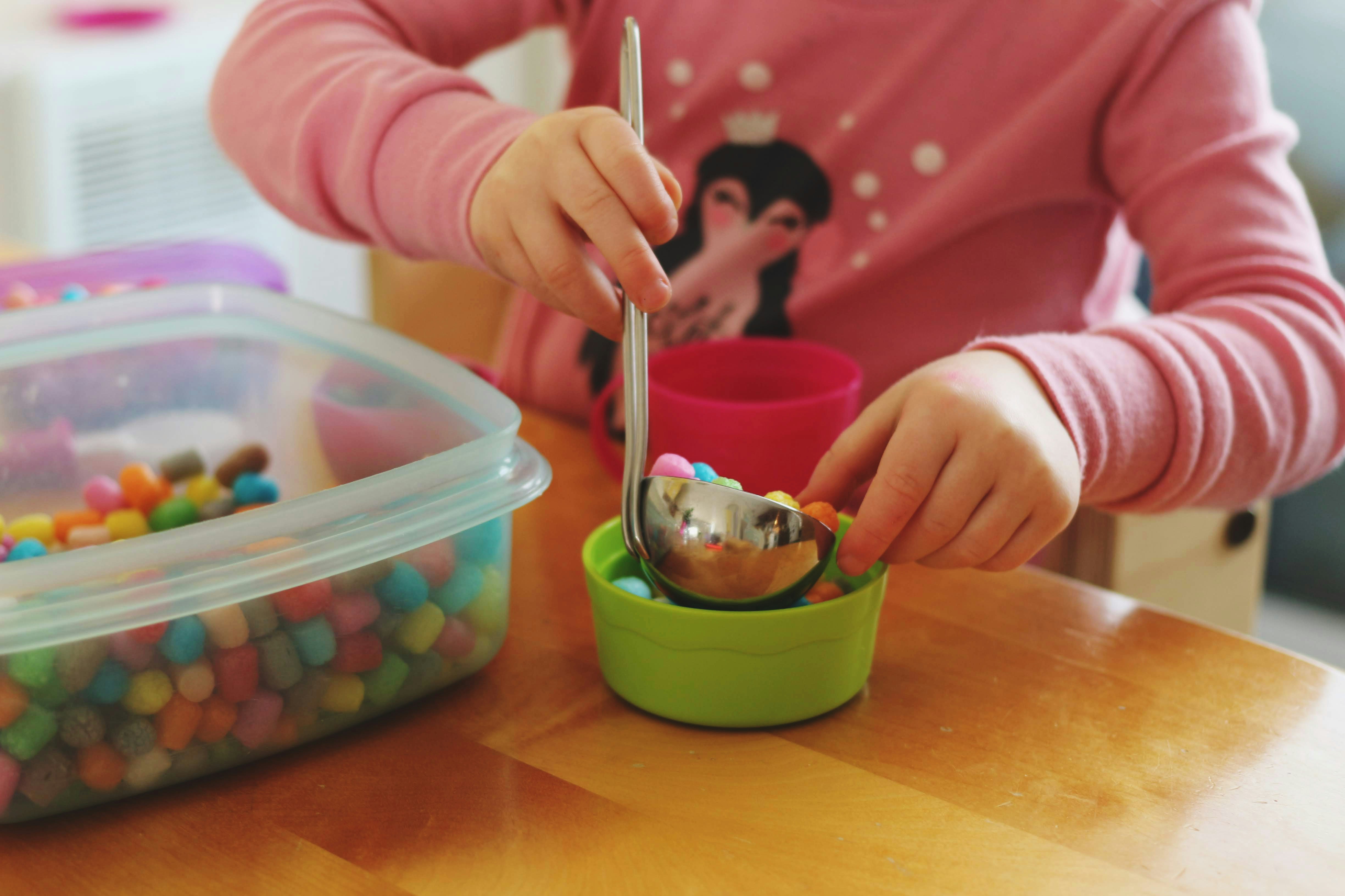 girl putting candies in bowl