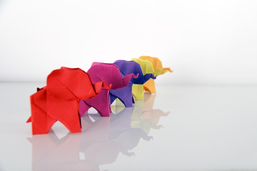 Cinque origami di elefanti di colori assortiti