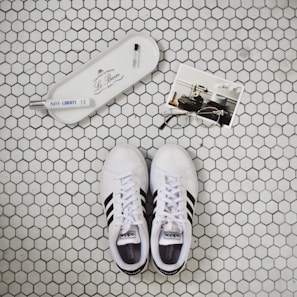 Flat lay of Shoe Lux cleaning kit alongside sparkling clean sneakers
