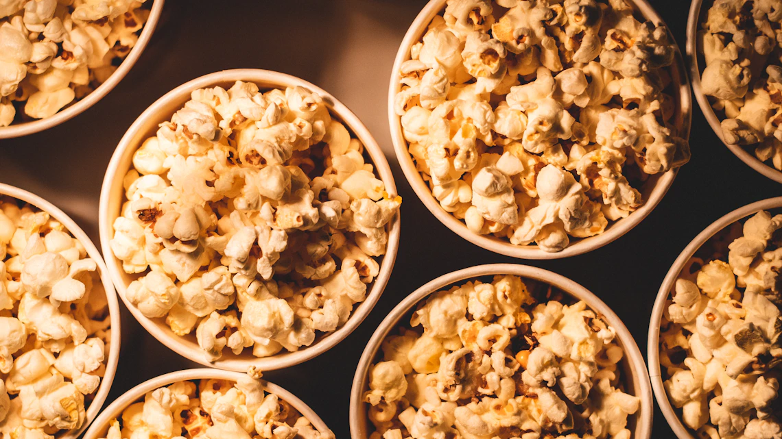 Several bowls of popcorn displayed together in a warm food photography composition.