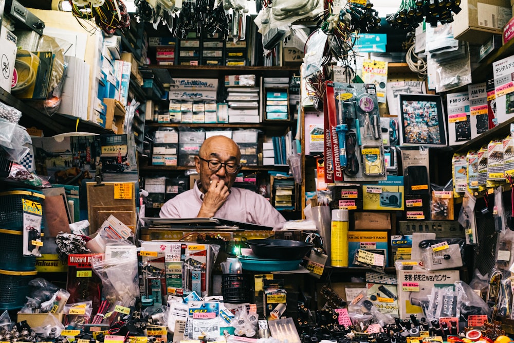 man standing beside assorted-color electronic and accessory packs