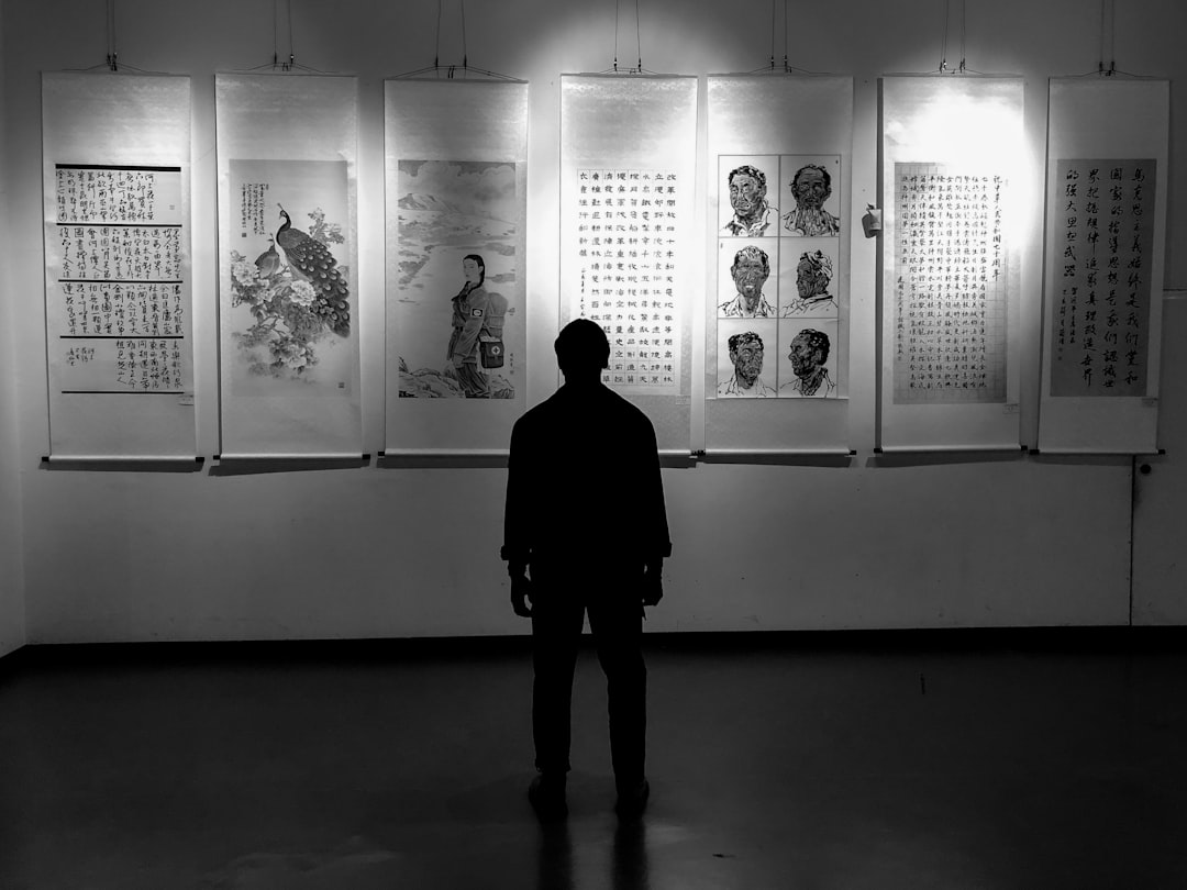 man looking at artworks