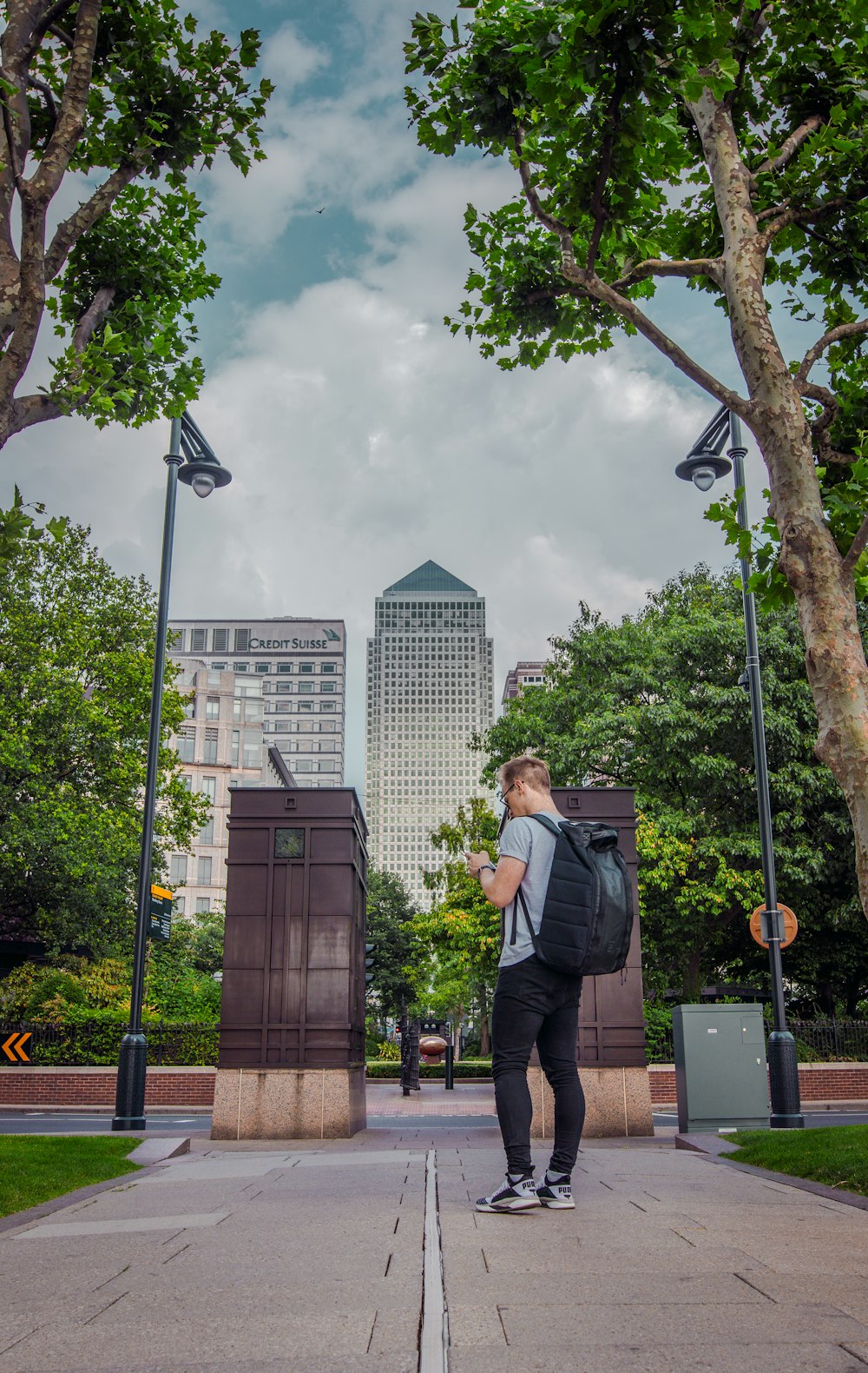 a man with a backpack standing in a park