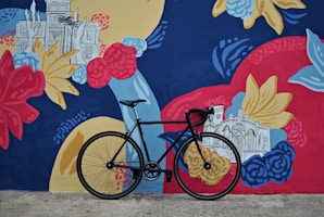 City bike parked near a colorful urban mural
