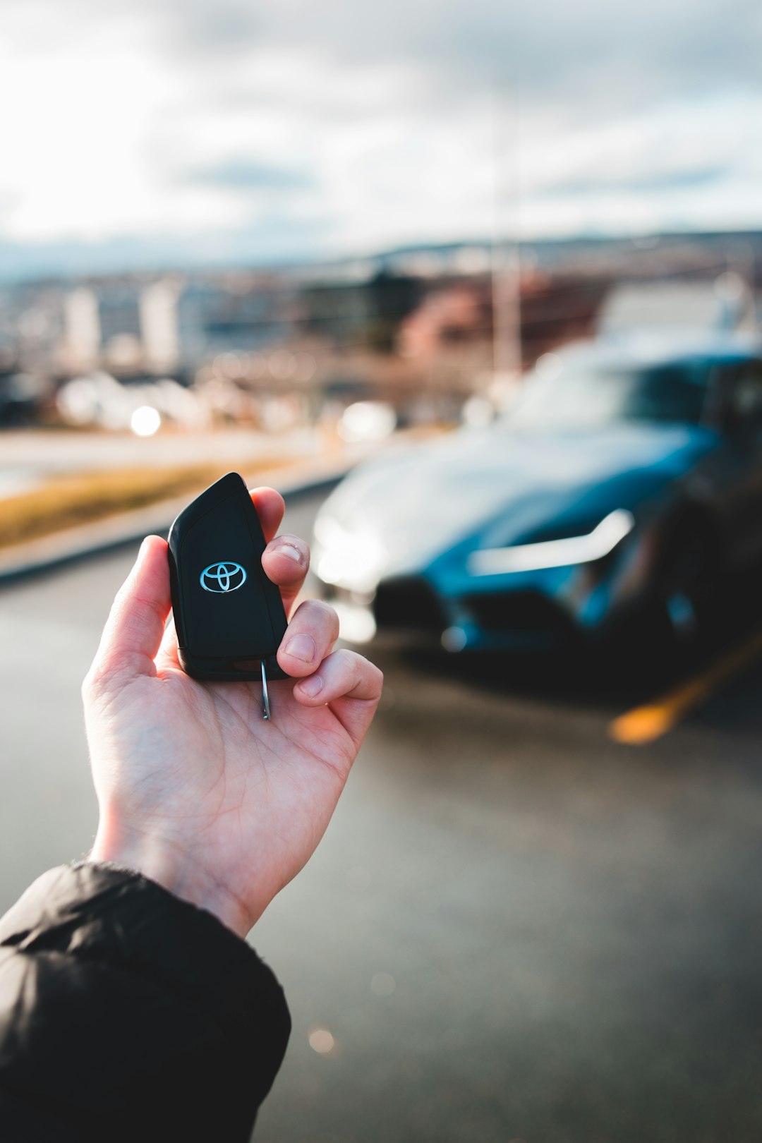 selective focus photo of person holding black Toyota key fob