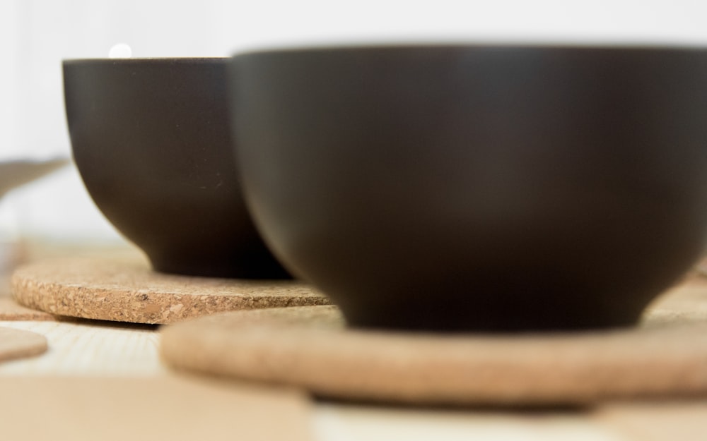 two black ceramic bowls on boards