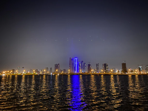 A sleek nighttime New York City skyline with glowing blue accents reflecting the brand colors.