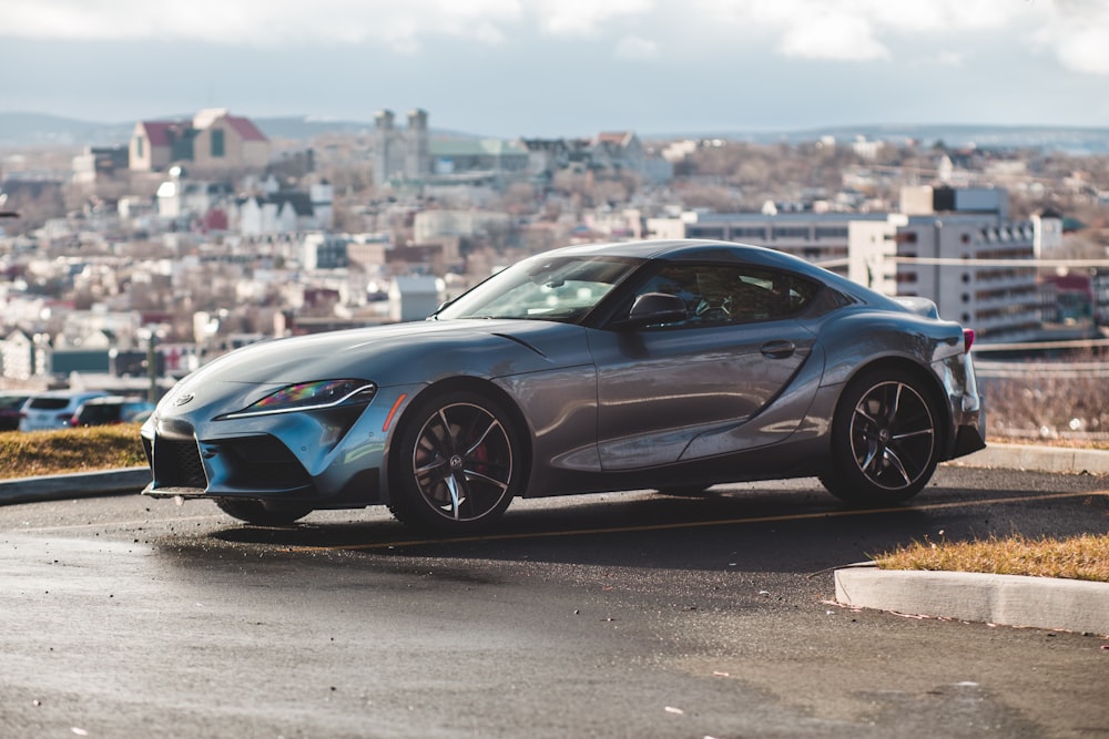 silver coupe parked on concrete pavement