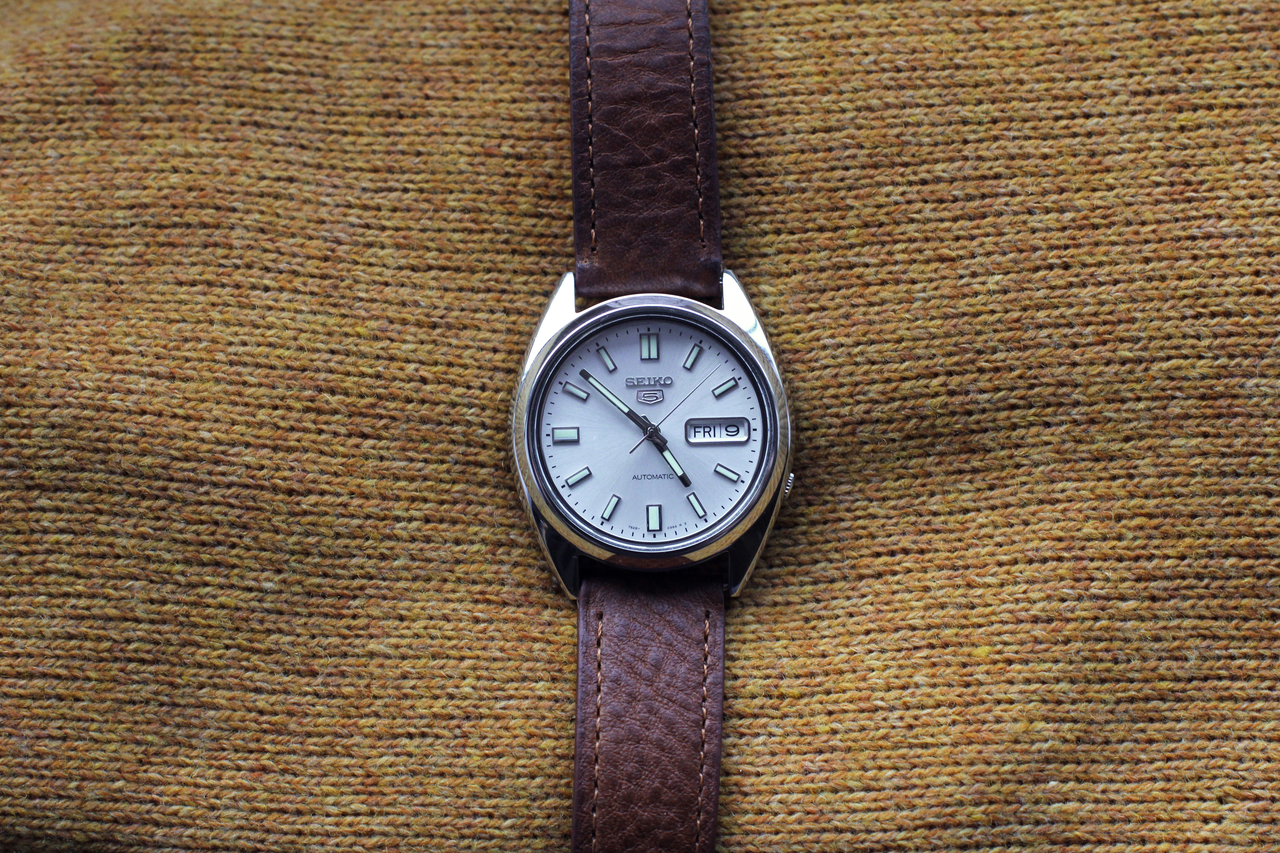 round white and silver-colored analog watch