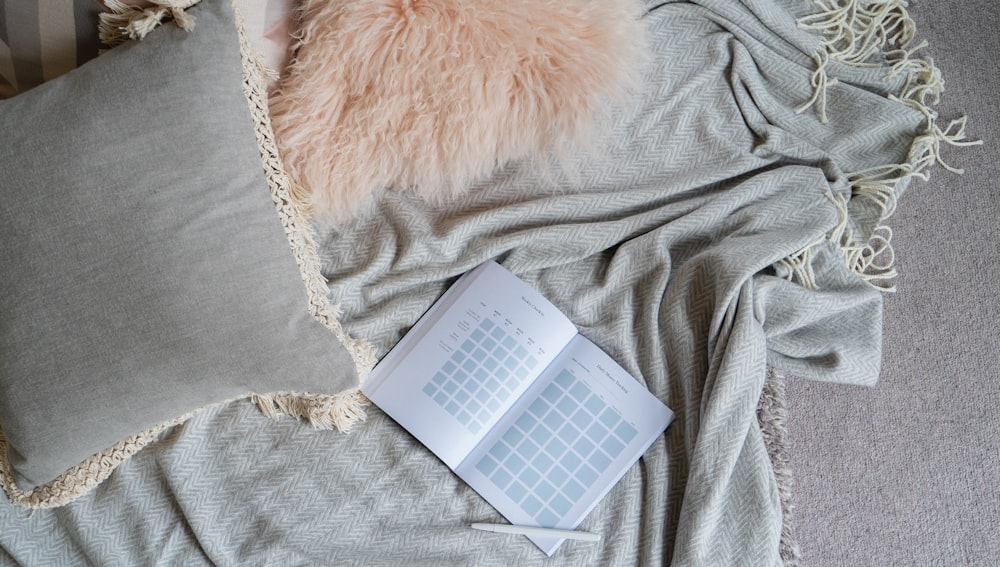 white book on gray textile