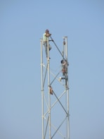 two person holding metal rod