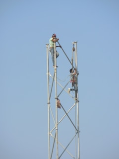 two person holding metal rod