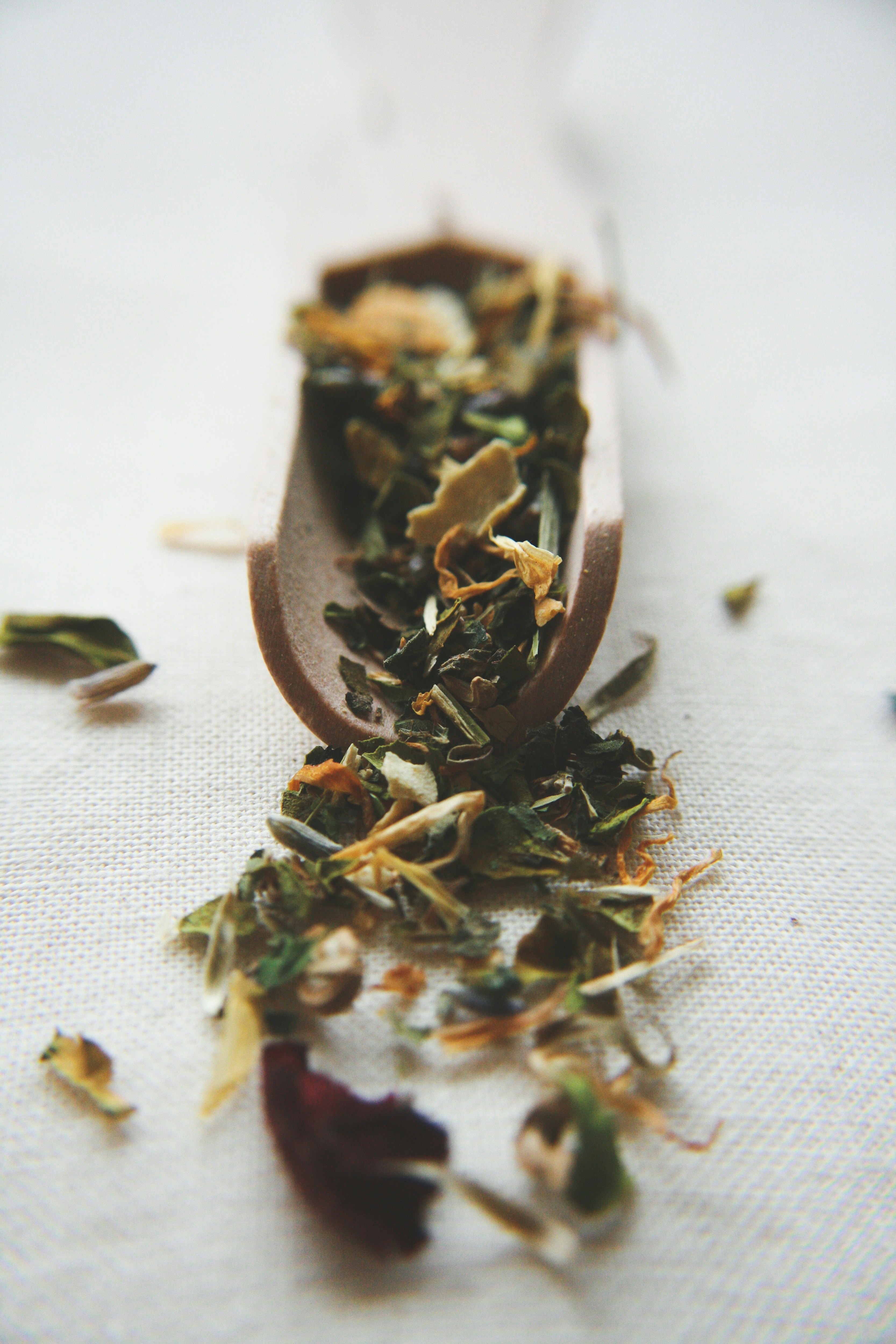 Pale yellow experimental ice cream scoop with herb garnish, rustic wooden board