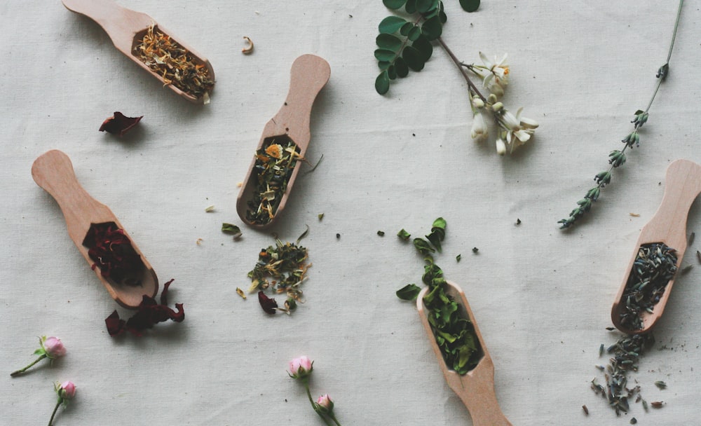 assorted seasoning on brown wooden spatulas