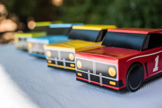A lineup of colorful remote control vehicles including a 2WD racecar, 4WD truck, and a dump truck on a smooth surface.