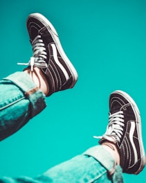 person wearing black-and-white Vans Sk8-Hi sneakers