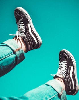 person wearing black-and-white Vans Sk8-Hi sneakers