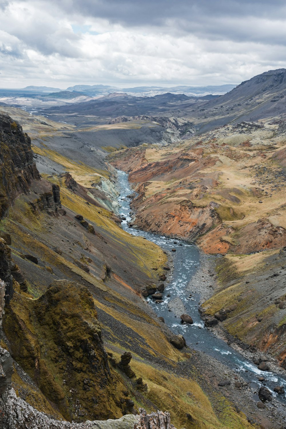 river between mountain during daytiem