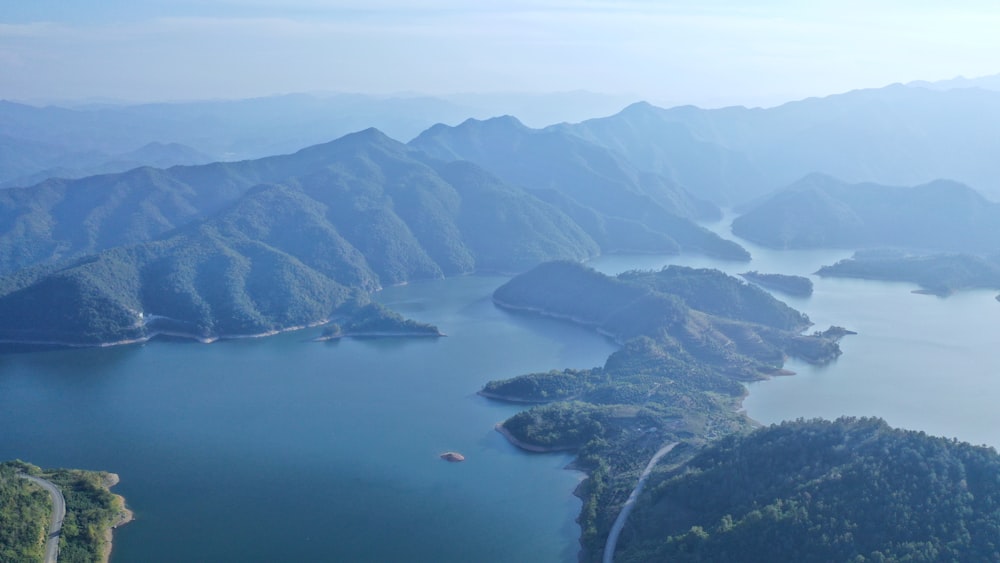 aerial photography of body of water viewing mountain under blue and white sky