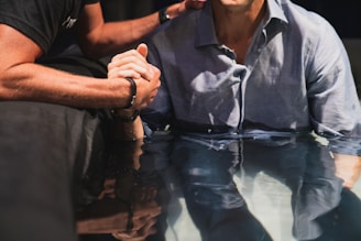 a man sitting at a table with his hand on his face