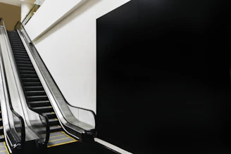 Technician installing a compact battery-powered escalator on a residential staircase.