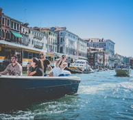 Tourists enjoying a leisurely boat ride along Dubai Creek with historic buildings in the background.