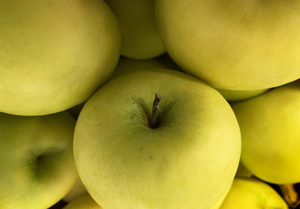 a pile of green apples sitting on top of each other