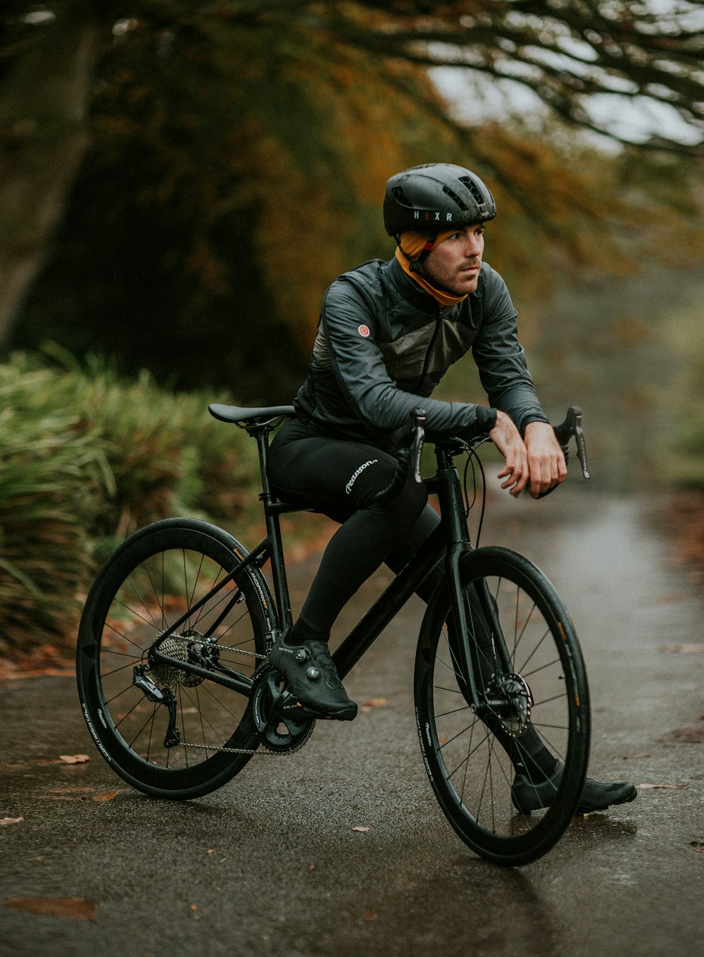 Mann sitzt auf Rennrad in der Nähe von Bäumen