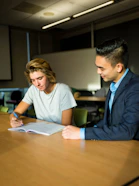 One-on-one mentoring session between a coach and a student in a modern learning space.